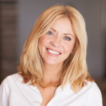 Middle aged woman smiling at the camera at home. White