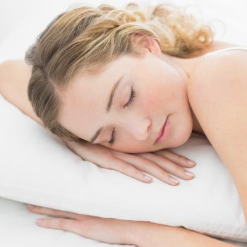 Pretty peaceful blonde lying in bed slumbering in bright bedroom